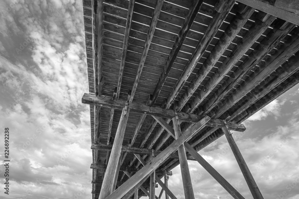 Black and white view under a pier in Carolina Beach, North Carolina, USA