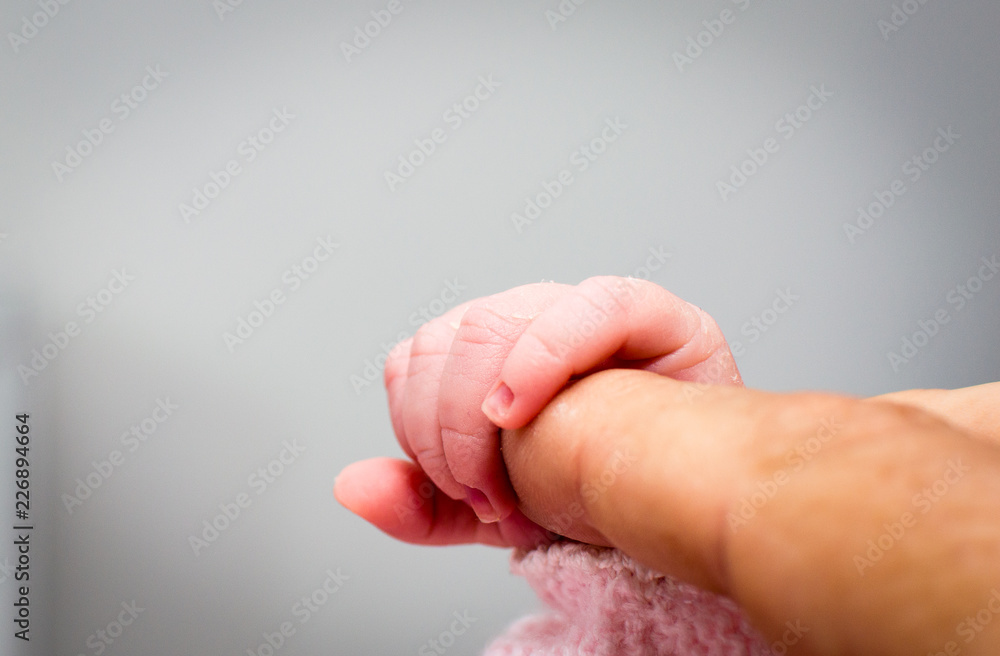 Close-up of baby's hand holding father's finger Close-up of baby's hand holding father's finger