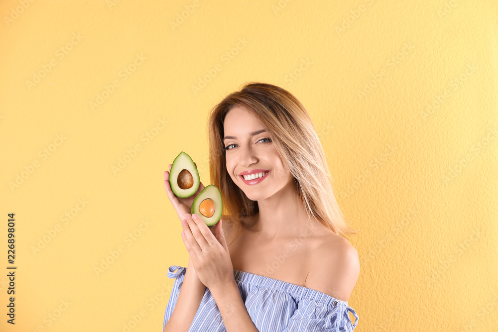 Portrait of young beautiful woman with ripe delicious avocado on color background Portrait of young beautiful woman with ripe delicious avocado on color background
