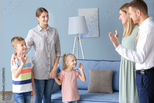Parents leaving their children with nanny at home photo