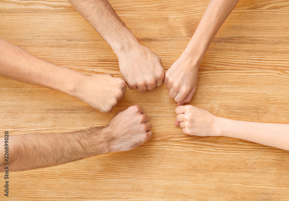 People putting fists together at table. Unity concept People putting fists together at table. Unity concept
