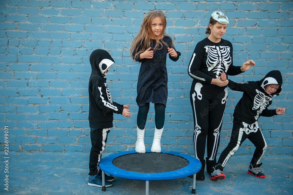 Cute children dressed up to celebrate Halloween in skeleton costumes