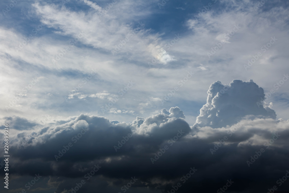 Clouds are shaped like a floating mountain, This cloud will rain, but top on the cloud have the sunlight, it feels like a clear sky