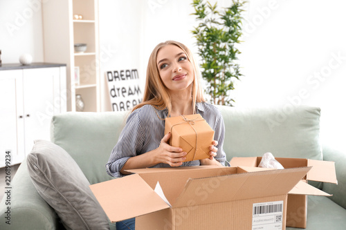 Young woman unpacking parce...