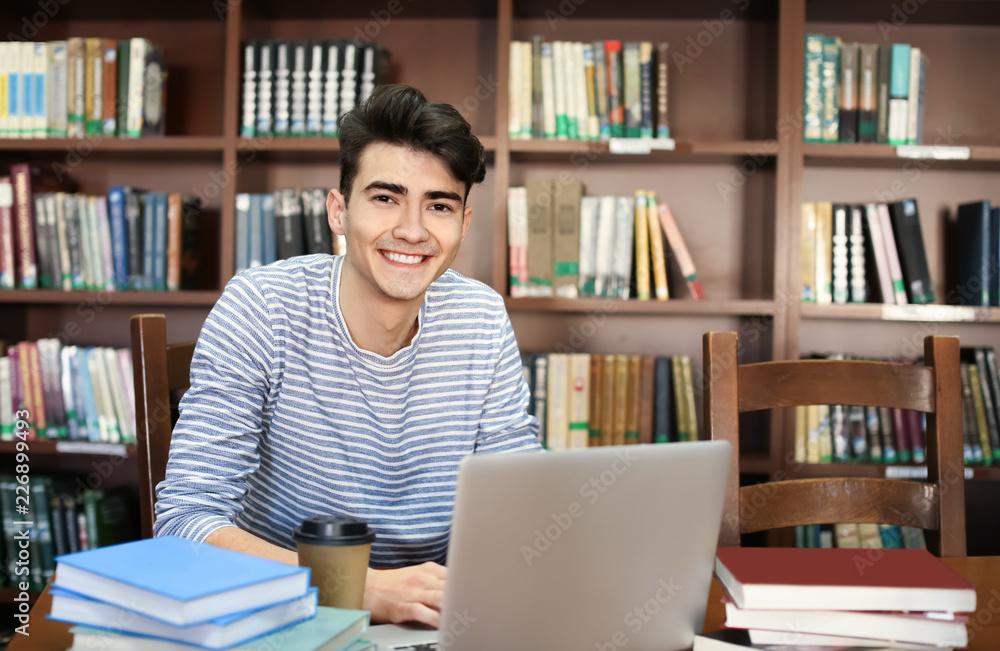 Student with laptop studying in library Student with laptop studying in library