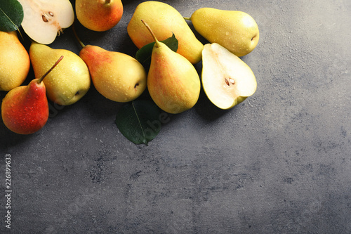 Ripe pears on grey background, top view. Space for text