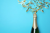 Creative flat lay composition with bottle of champagne and space for text on color background