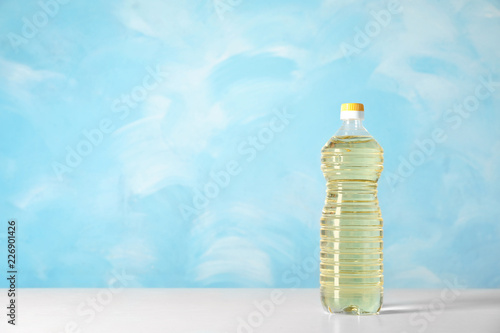 Fototapeta Naklejka Na Ścianę i Meble -  Bottle of oil on table against color background. Space for text