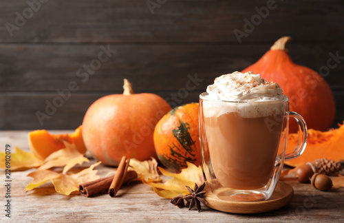 Obraz na plátne Glass cup with tasty pumpkin spice latte on wooden table