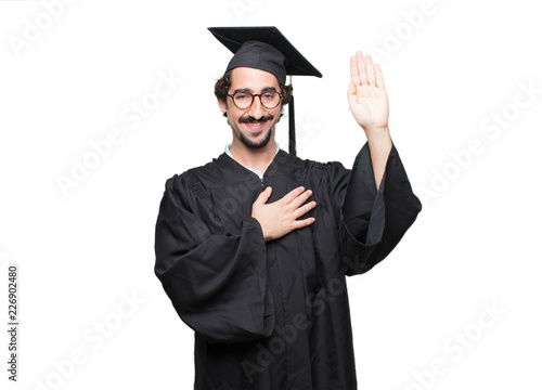 фотографія graduate bearded man smiling confidently while making a sincere promise or oath, solemnly swearing with one hand over heart