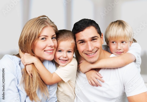 Beautiful smiling family sitting at sofa at