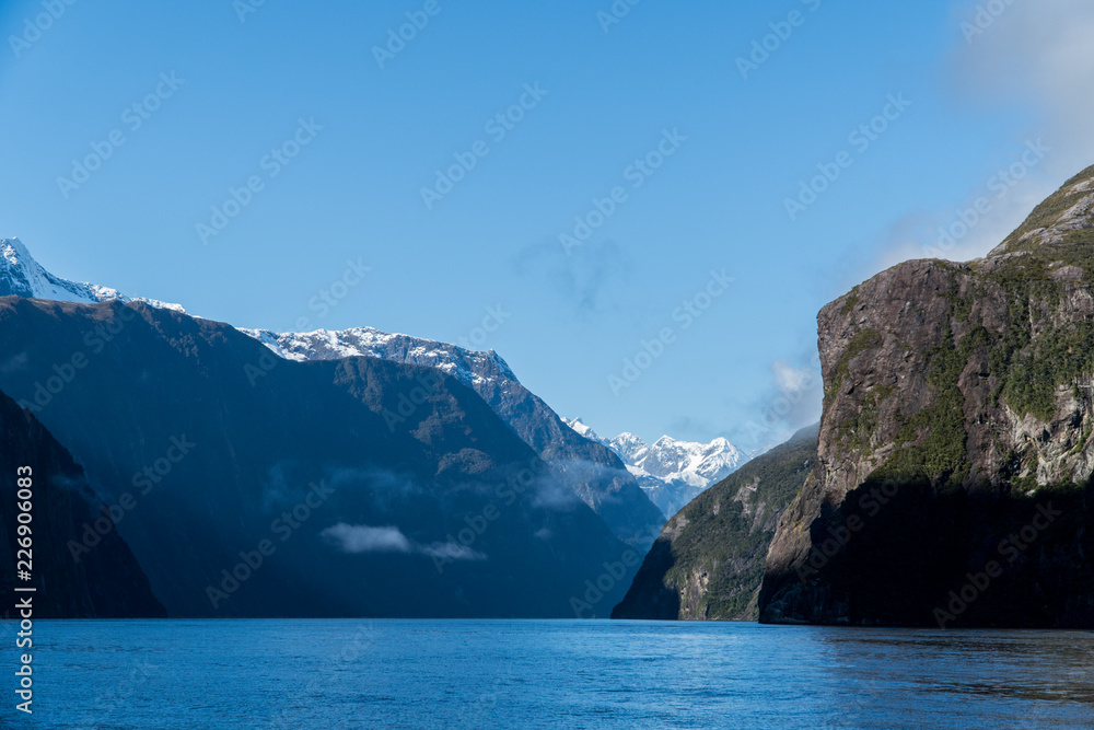 rocks and snow capped mountains in Milford Sound, New Zealand