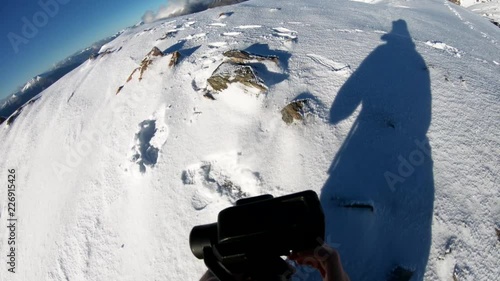 Setting up camera on snowy mountain, POV
