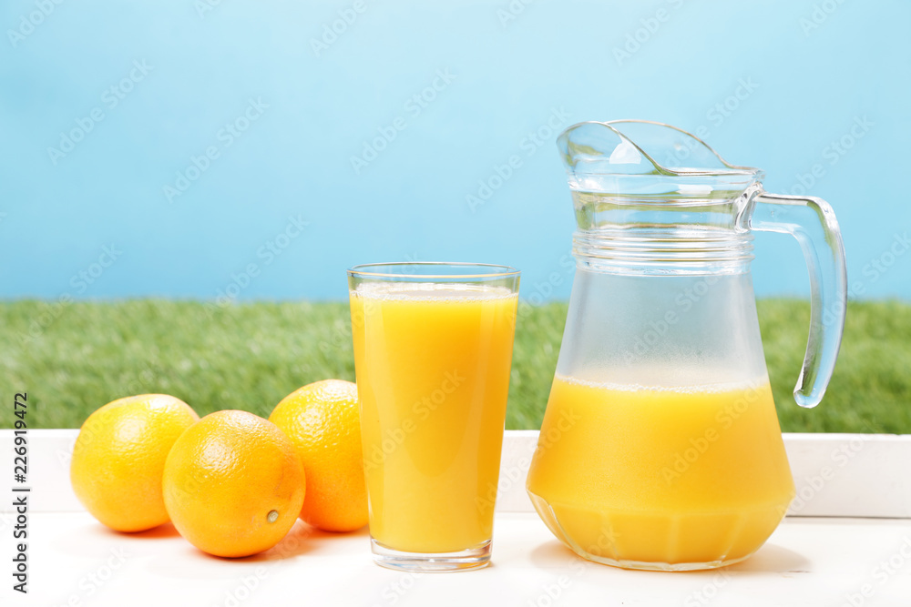 Fresh oranges, glass and jar full of orange juice Fresh oranges, glass and jar full of orange juice