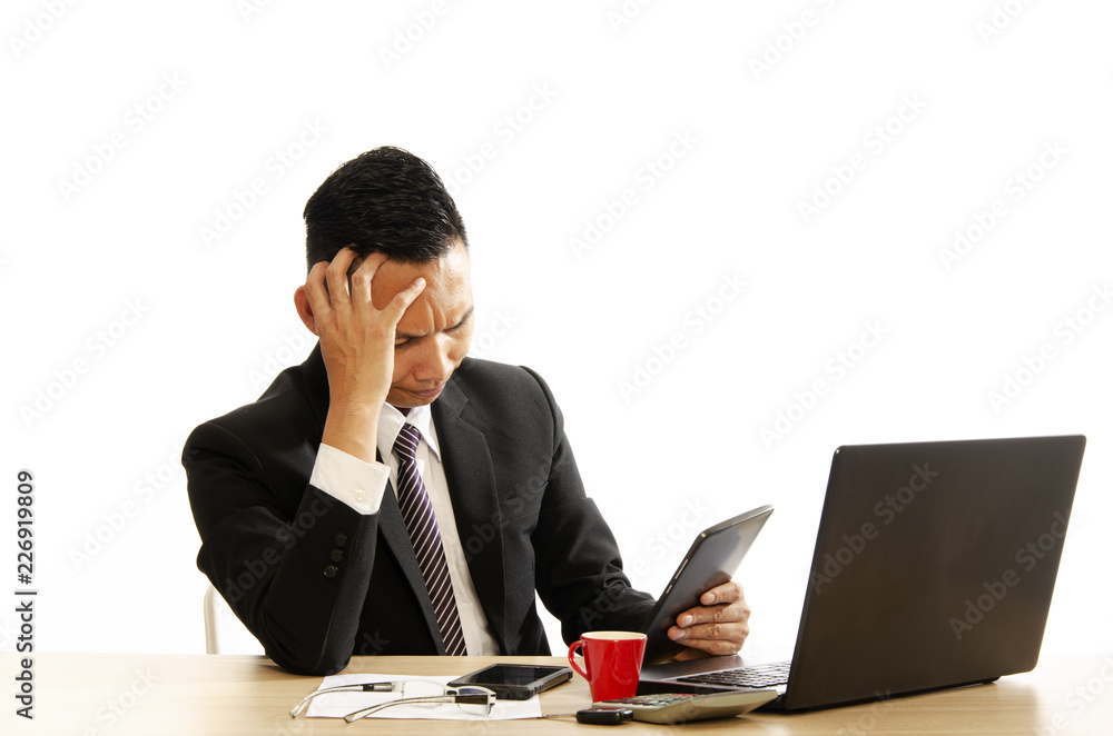 Asian business man looking into his tablet computer and having headache Asian business man looking into his tablet computer and having headache