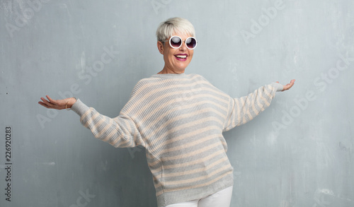 senior cool woman against grunge cement wall.