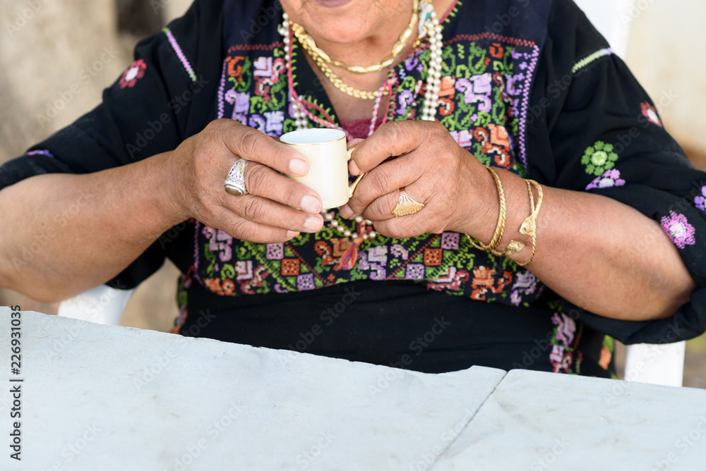 Close up of old Arab woman hands with traditional arabian dress and jewelry  holding cup of coffee. Stock Photo | Adobe Stock