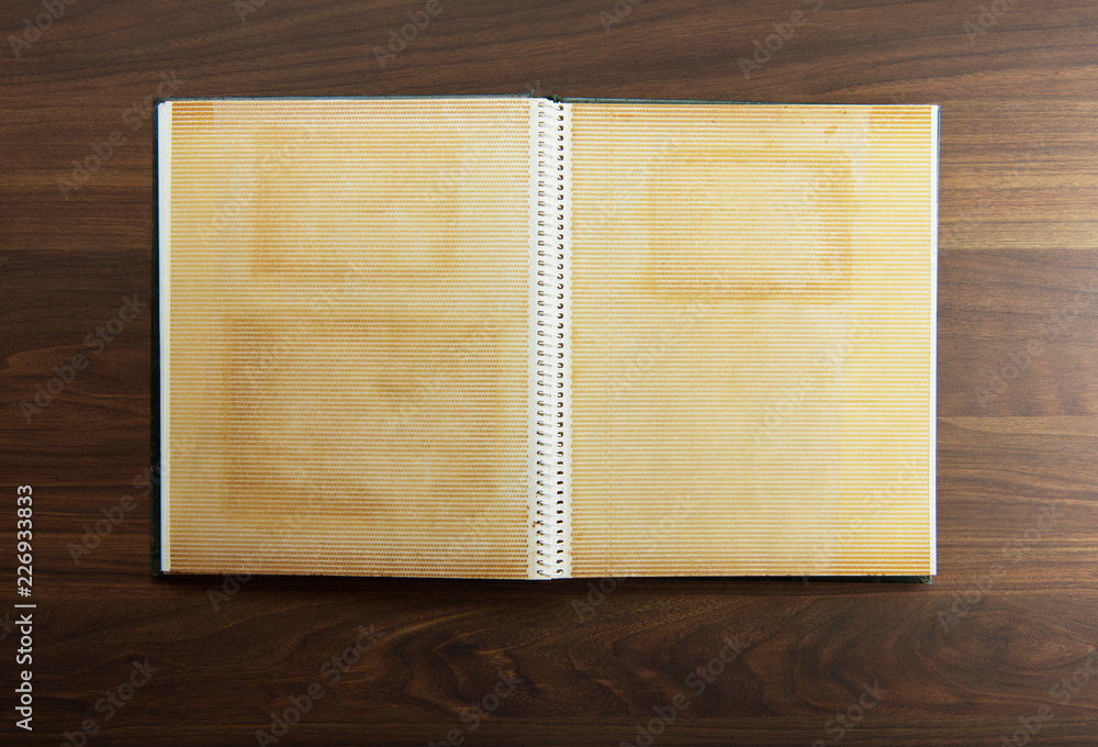 Blank page of an 1970s photo album, on a dark colored wooden table. - obrazy, fototapety, plakaty 