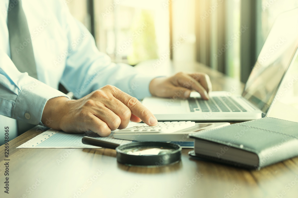 Businessman work with computer on table in office work with paper graph chart Businessman work with computer on table in office work with paper graph chart