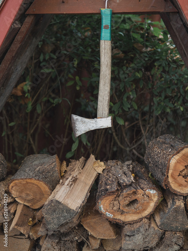 Wooden background. Firewood for the winter, stacks of firewood with axe.