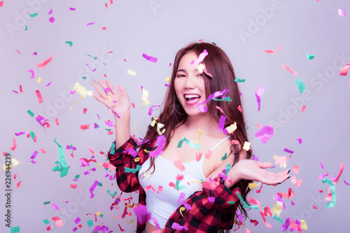 Charming beautiful young woman gets cheerful and happiness with smile and dance. Attractive beautiful women is celebrating some party, festival, new year or carnival with fireworks rainbow colors