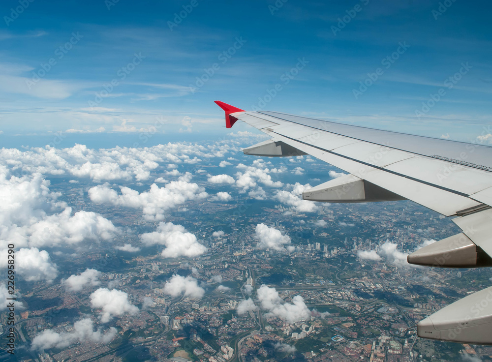 Fototapeta premium wing of airplane flying above clouds