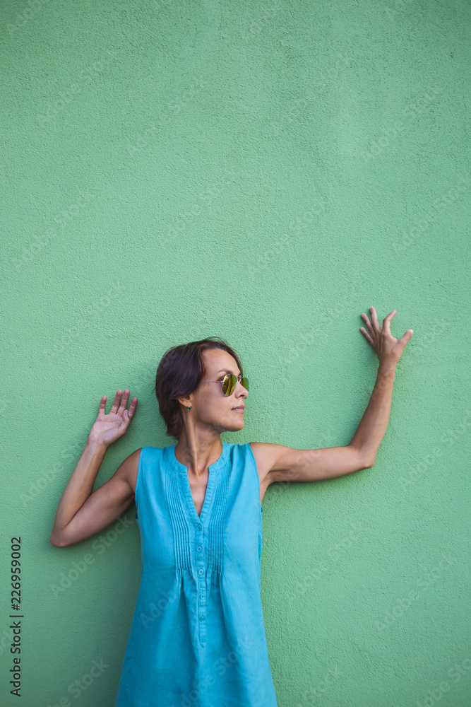 Woman in a dress on a wall background. Woman in a dress on a wall background.