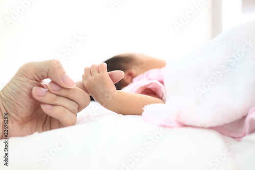 close up new born baby's small hand. baby holding on to her mother's Finger. 