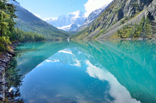 The reflection of the mountains Skazka and Krasavitsa (Tale and Beautiful) in a Large Shavlinskoye lake in sunny day, Altai mountains, Russia