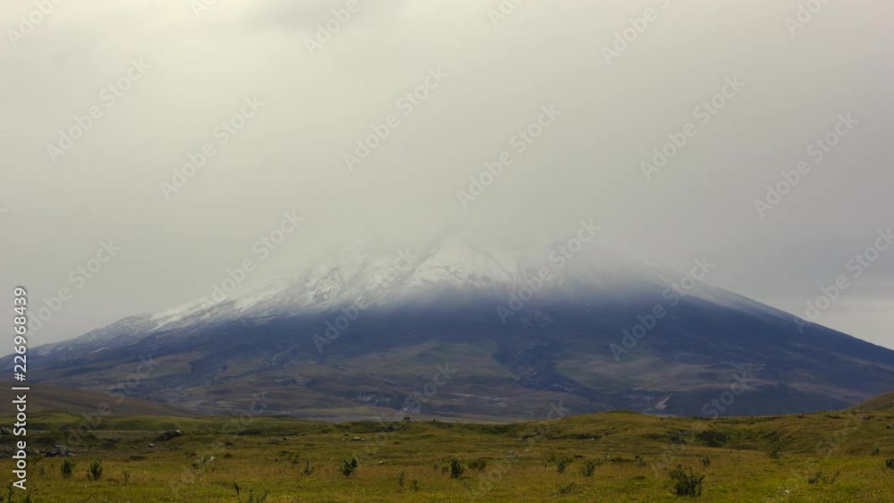 Cotopaxi Volcano time-lapse. Emerging from the mist after a fresh snowfall. A group of cattle in the distance. The second highest mountain in Ecuador, 5897m. Cotopaxi Volcano time-lapse. Emerging from the mist after a fresh snowfall. A group of cattle in the distance. The second highest mountain in Ecuador, 5897m.