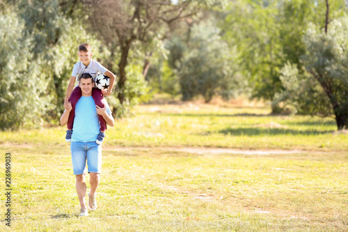 Little boy and his dad with soccer ball outdoors © Pixel-Shot