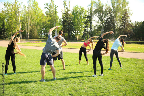 Group of sporty people training in park