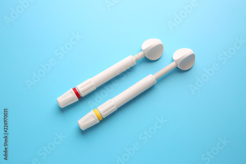 Syringes of resin luting cement on color background