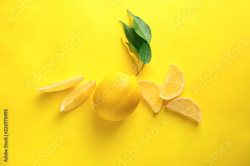 Ripe whole lemon and slices on color background