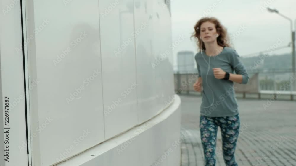 Pretty smiling fitness woman using running app before the run for track the pace on smartwatch, happy smiling sportive girl texting message on smartphone before morning workout Pretty smiling fitness woman using running app before the run for track the pace on smartwatch, happy smiling sportive girl texting message on smartphone before morning workout