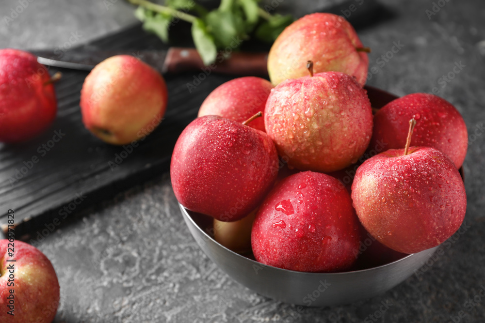 Bowl with ripe juicy apples on grey table Bowl with ripe juicy apples on grey table