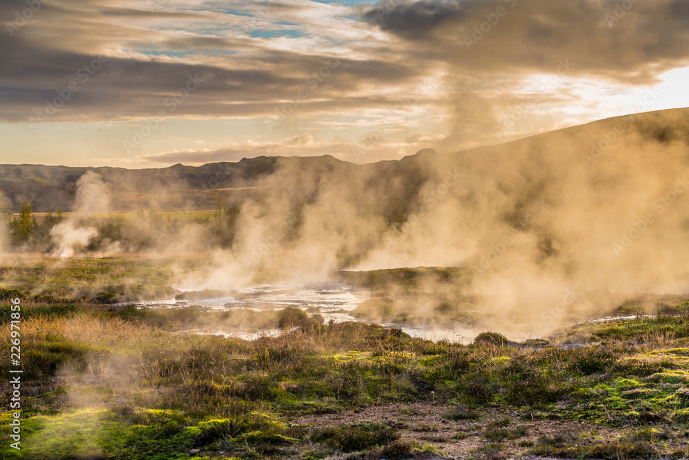 Fototapeta premium Landscape around geyser with fog patches in a sunset environment 