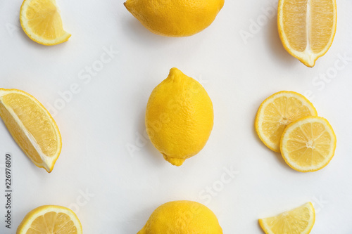 Flat lay composition with ripe juicy lemons on white background