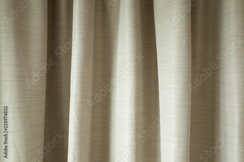 beige fabric curtains in bedroom; interior design concept.