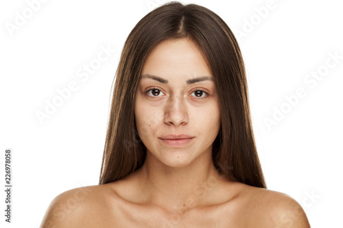 Portrait of young beautiful woman with no makeup on white backgeound