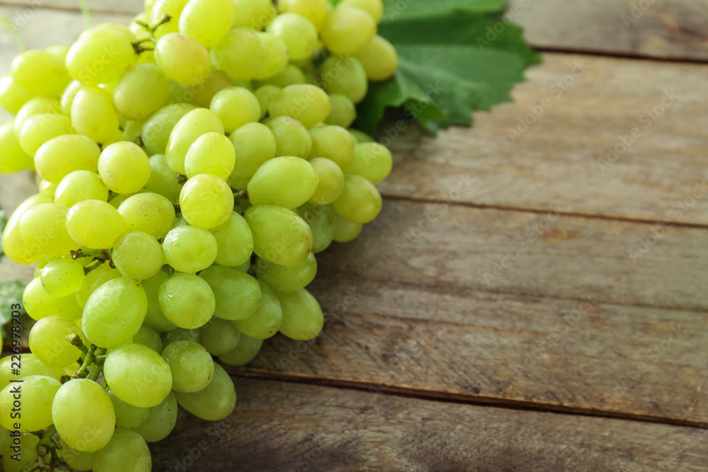 Ripe juicy grapes on wooden table Ripe juicy grapes on wooden table