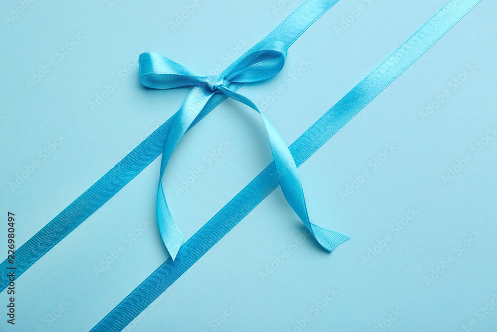 Blue ribbons with bow on color background Blue ribbons with bow on color background
