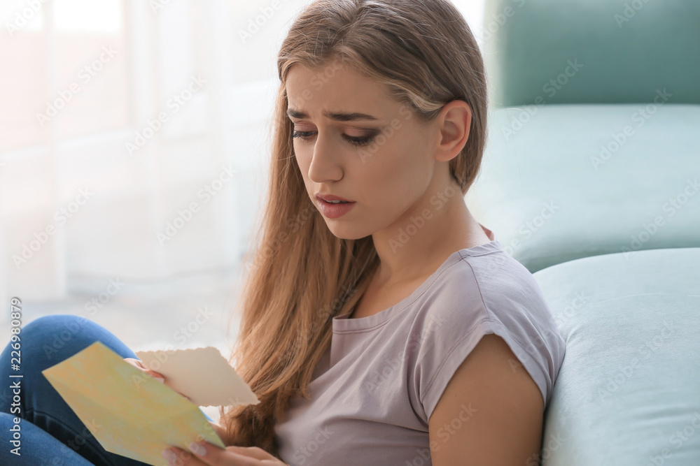 Lonely depressed woman reading letter at home Lonely depressed woman reading letter at home