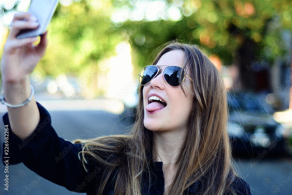 Young woman taking selfie with her smartphone. Young woman taking selfie with her smartphone.