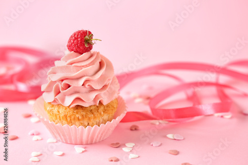 Delicious birthday cupcake on color table