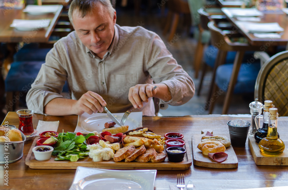 The man is eating breakfast in the restaurant. The man is eating breakfast in the restaurant.