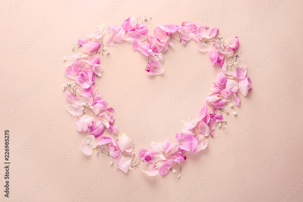 Heart made of flower petals on color background