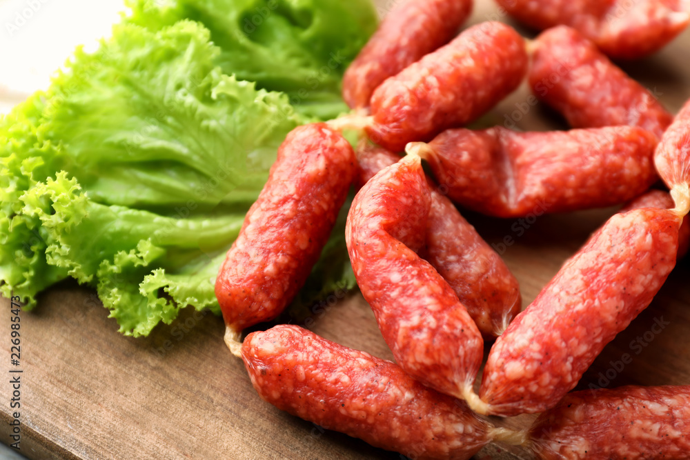 Delicious smoked sausages on wooden board, closeup Delicious smoked sausages on wooden board, closeup