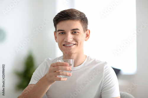 Young man with glass of wat...