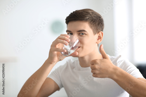 Young man drinking water at...
